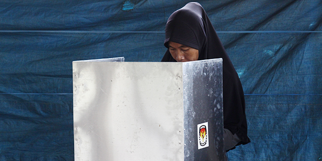 A woman votes at a polling station during an Indonesian regional election in June. (Aditya Irawan/NurPhoto via Getty Images)