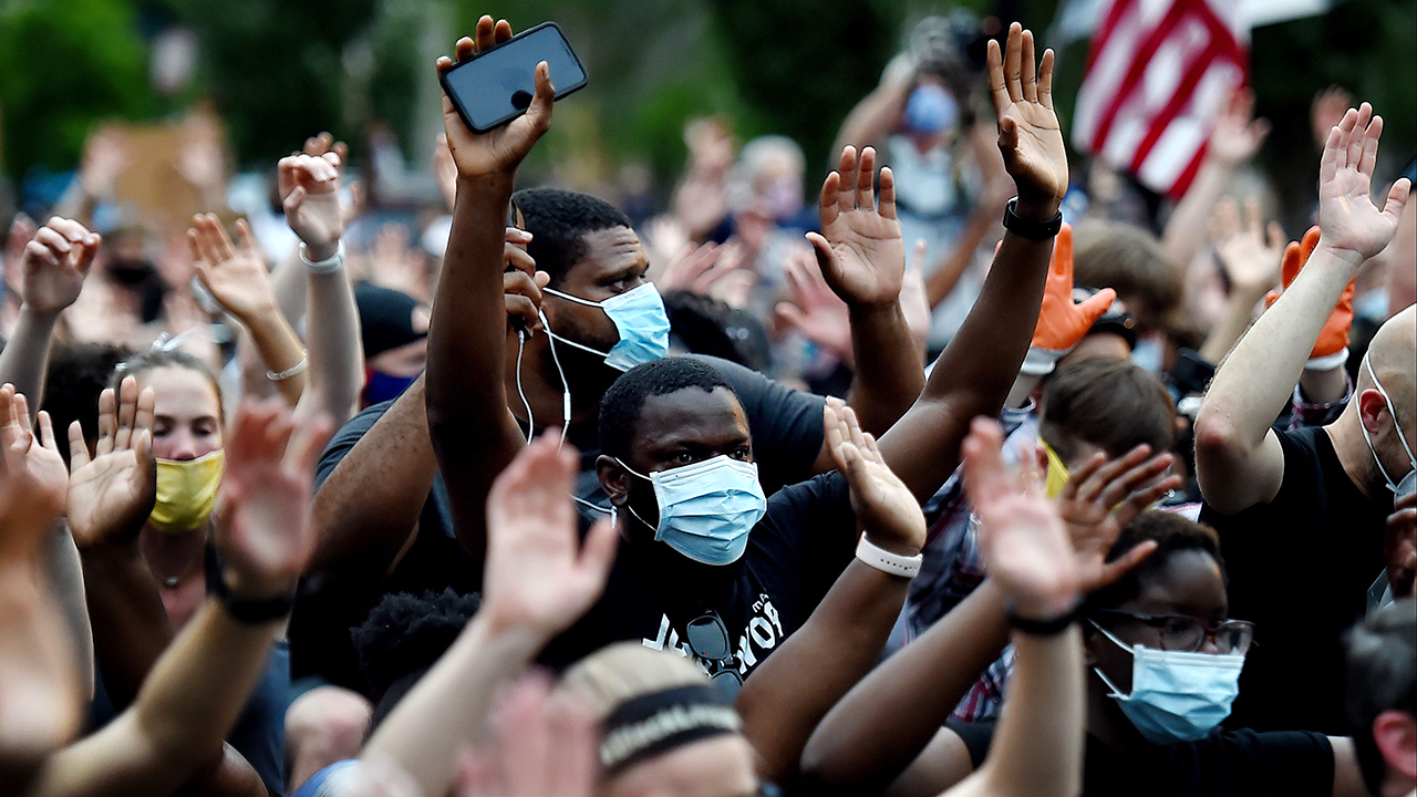Protesters kneel and hold up their hands in front of Lafayette park near the White House to protest the death of George Floyd, who died in police custody in Minneapolis on June 4, 2020 in Washington, DC. (Photo by OLIVIER DOULIERY/AFP via Getty Images)