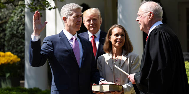 Neil Gorsuch is sworn in as the newest member of the U.S. Supreme Court by Justice Anthony Kennedy in a White House Rose Garden ceremony on April 10, 2017. President Donald Trump, who appointed him, looks on as Gorsuch's wife, Louise, holds the Bible. (Xinhua/Yin Bogu via Getty Images)