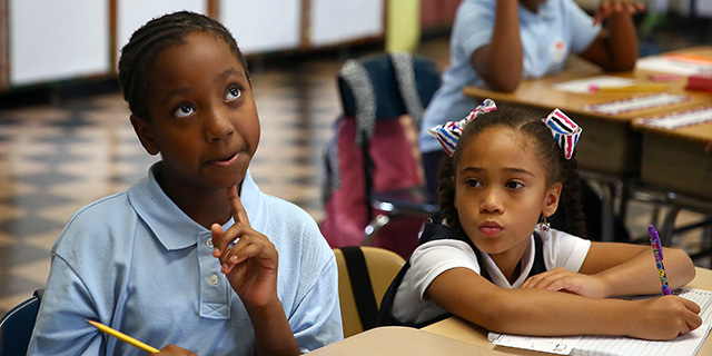 Nalani Reid ponders a math word problem on the first day of fourth grade in September 2016 at David A. Ellis Elementary School in Boston. Classmate Alanis Vega sits at right. (Pat Greenhouse/The Boston Globe via Getty Images)