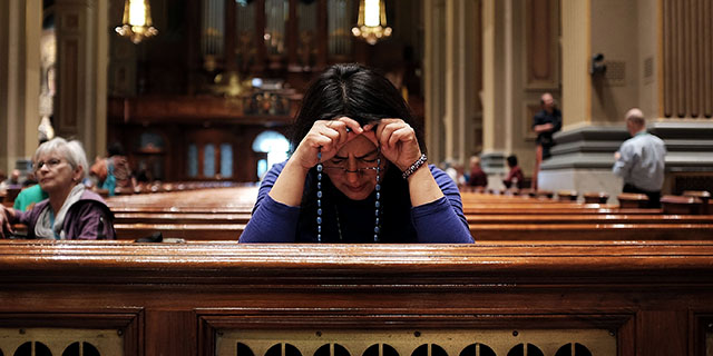 A woman prays at the Cathedral Basilica of Saints Peter and Paul in Philadelphia. (Spencer Platt/Getty Images)