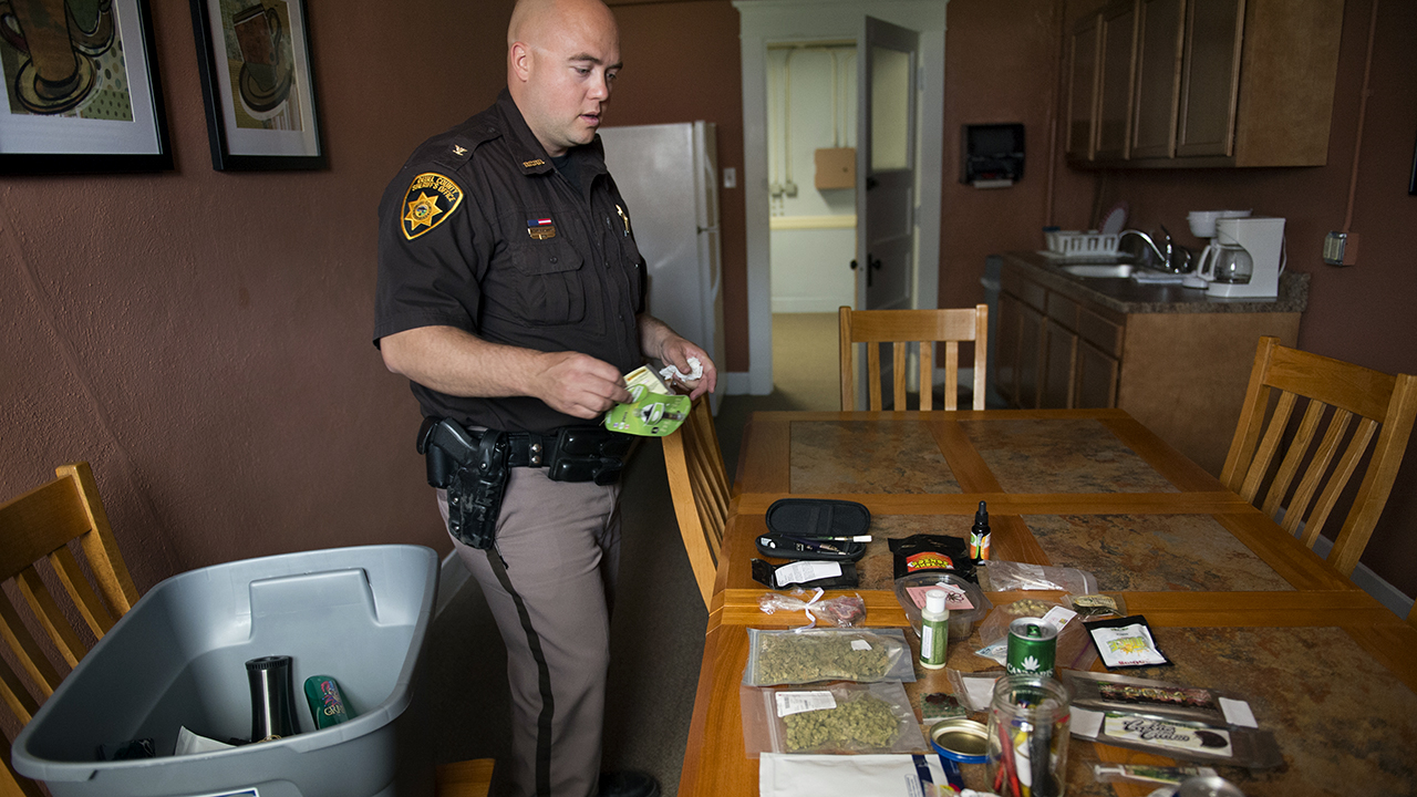 Deuel County's then-sheriff, Adam Hayward, displays confiscated marijuana items in Chappell, Nebraska, in 2014. (Nikki Kahn/The Washington Post via Getty Images)
