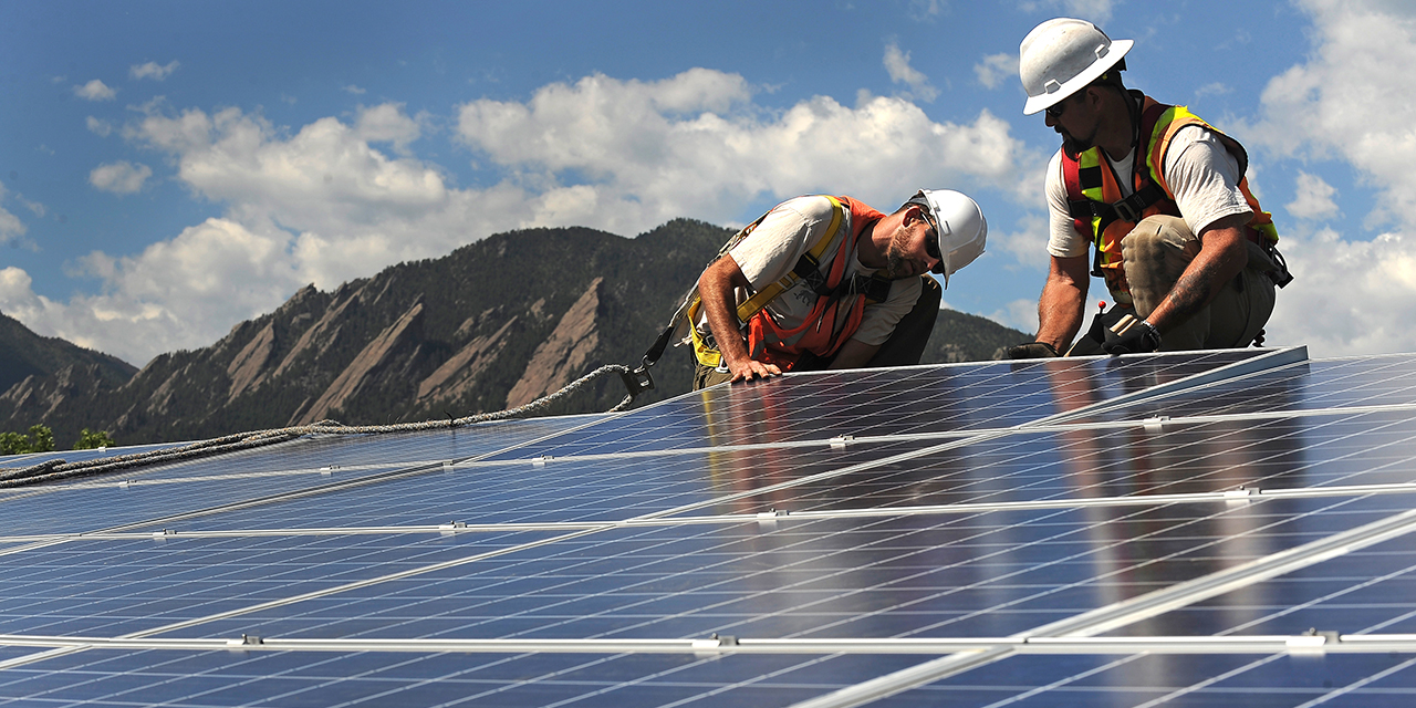 Workers install solar panels on a rooftop in Boulder, Colorado. (Helen H. Richardson/The Denver Post via Getty Images)