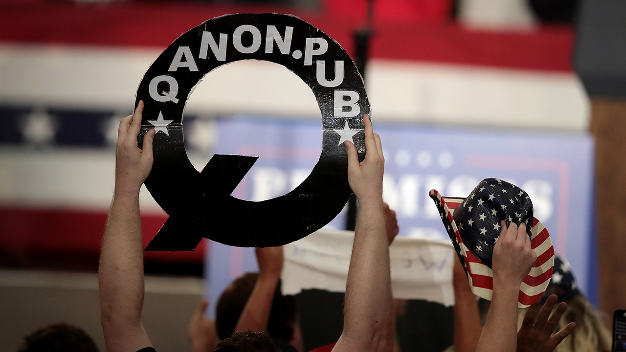 A person holds up a sign about QAnon at a political rally in Ohio in 2018. (Scott Olson/Getty Images)