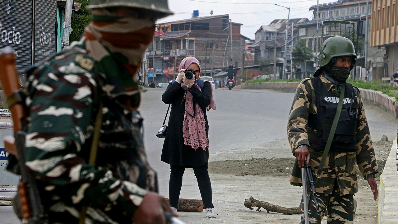 Photojournalist Masrat Zahra takes pictures near a temporary checkpoint in Srinagar, in Indian-controlled Kashnmir, on April 21. (Faisal Khan/Anadolu Agency via Getty Images)