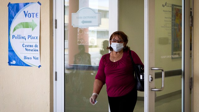 A woman wearing a protective mask and gloves leaves after voting in Florida's Democratic primary election at Miami-Dade Public Library Little Havana in Miami on March 17, 2020. (Eva Marie Uzcategui/AFP via Getty Images)