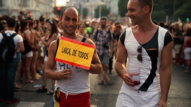 A man holds a sign depicting the Spanish flag and calling for nonreligious education during the 2013 Madrid Gay Pride Parade. (Gonzalo Arroyo via Getty Images)