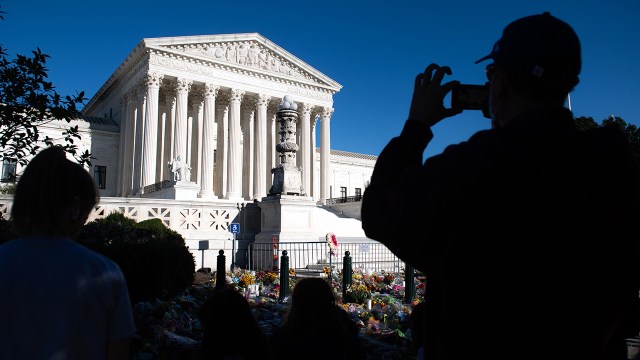 A visitor takes photos near a makeshift memorial for late U.S. Supreme Court Justice Ruth Bader Ginsburg at the U.S. Supreme Court on Sept. 21, 2020. (Saul Loeb/AFP via Getty Images)