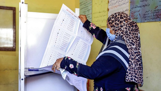 A voter unfolds her ballot at a polling station in el-Ayyat, Egypt, on Aug. 11, 2020. (AFP via Getty Images)