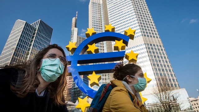 Students in masks pass the Euro sculpture in downtown Frankfurt, Germany, in March 2020. Restrictions had taken effect the week before to stem the spread of the coronavirus. (Thomas Lohnes/Getty Images)