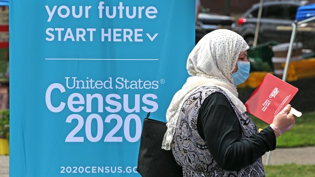 A woman waits at a Census 2020 booth at a farmers market in Everett, Massachusetts, in July. (David L. Ryan/The Boston Globe via Getty Images)