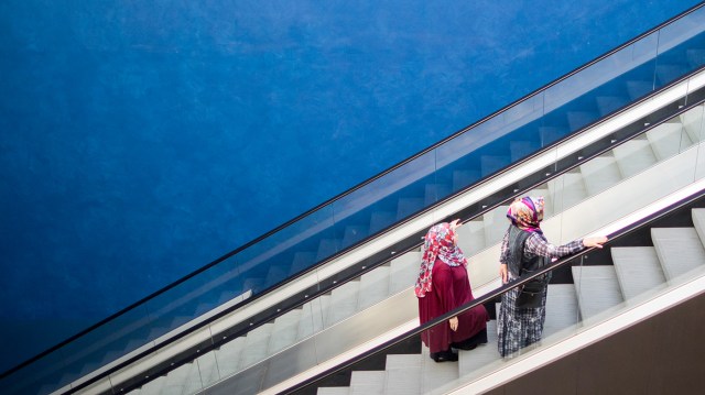 Two women wearing headscarves stand on an escalator in Essen, Germany, in 2018. (Rolf Vennenbernd/DPA/AFP via Getty Images)