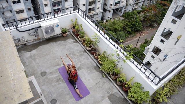 Yoga instructor Pratibha Agarwal practices yoga on a building's terrace in Hyderabad, India, in June 2020. (Noah Seelam/AFP via Getty Images)