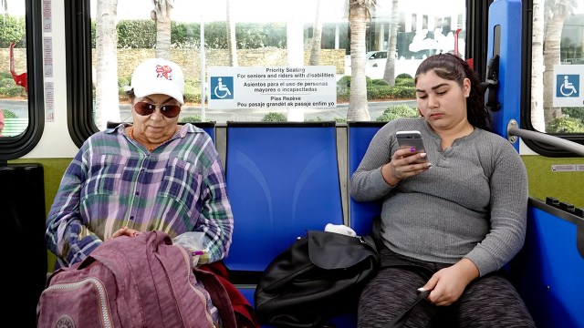 Passengers on a Florida bus look at their smartphones.