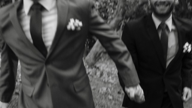 Two grooms hold hands while walking. (Unsplash/Maico Pereira)