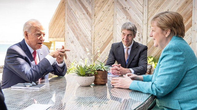 German Chancellor Angela Merkel and U.S. President Joe Biden meet at the sidelines of the G7 summit in Cornwall, England, together with Merkel’s foreign policy adviser Jan Hecker on June 12, 2021.