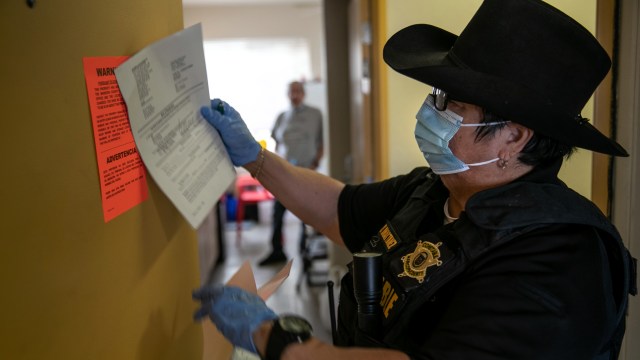 A Maricopa County constable posts an eviction order for nonpayment of rent in Phoenix on Oct. 1, 2020, despite a nationwide moratorium then in place on evictions from the Centers for Disease Control and Prevention during the coronavirus pandemic. 