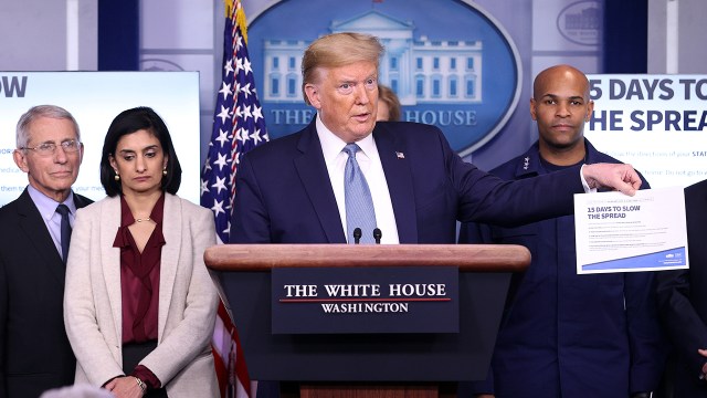 Then-President Donald Trump, flanked by members of his coronavirus task force, speaks to reporters at the White House on March 16, 2020.