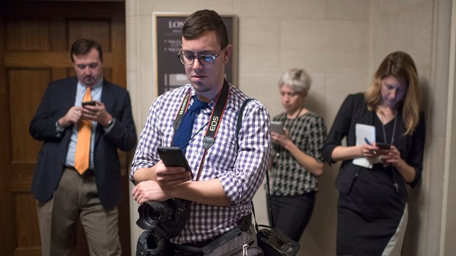 Journalists check their phones during the House leadership elections on Nov. 30, 2016, in the Longworth Building on Capitol Hill.