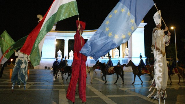 Hungarian men dance with EU and Hungarian flags in May 2004 in Budapest, Hungary.