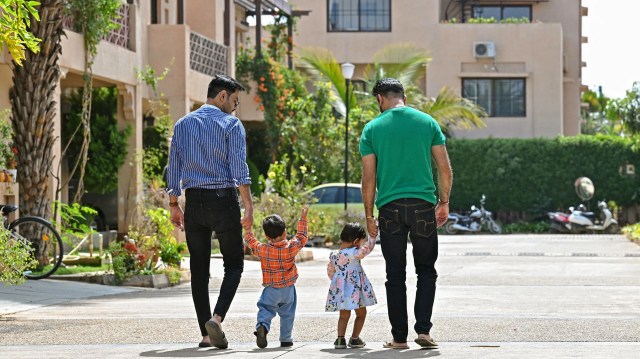 A same-sex couple walks outside their home with their children in Bengaluru, India. (Manjunath Kiran/AFP via Getty Images)