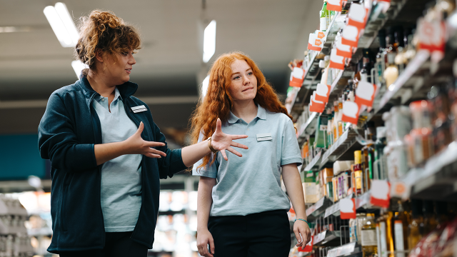 Grocery store manager explaining work to a new saleswoman.