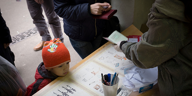 A refugee child at the Berlin administration facility for health and social welfare waits to receive toiletries from volunteers. (Colin McPherson/Corbis via Getty Images)