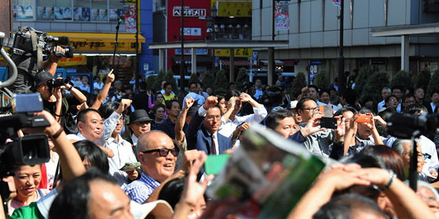 People listen to a street speech in Tokyo as the House of Representatives election campaign kicks off on Oct. 10. (The Asahi Shimbun via Getty Images)
