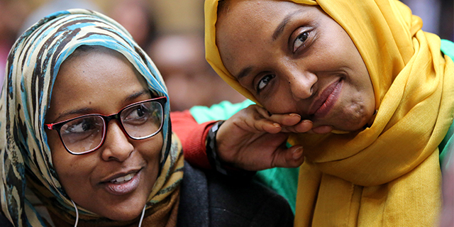 Shugri Elmi and Mariam Cheick listen to a speaker during Immigrants' Day at the Massachusetts State House in Boston on April 4. Both immigrated from Somalia and became citizens. (Craig F. Walker/The Boston Globe via Getty Images)